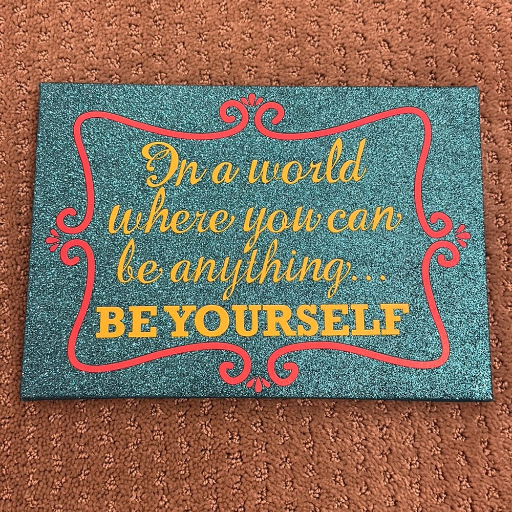 “In a world where you can be anything be yourself” sign